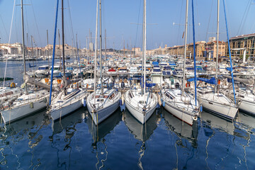 White yachts reflected in still water in the Old Port of Marseille, France. Front view.
