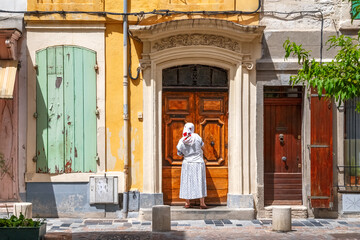 Arles, France. Authentic street, partial view of the facades of the houses, wooden doors and windows with shutters in the old town.