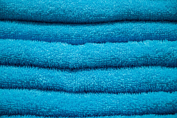 Texture of blue terry towel. A stack of soft bath accessories.