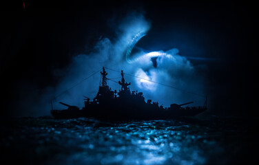 Fototapeta premium Silhouettes of a crowd standing at blurred military war ship on foggy background. Selective focus.