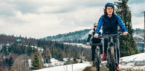 Aktywna młodzież w górach na rowerach górskich, radość z jazdy na rowerze elektrycznym o każdej porze roku, hartowanie organizmu przez uprawianie sportu na świeżym powietrzu