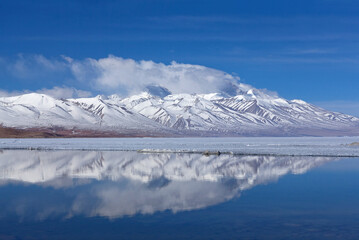 Holy Lake Manasarovar under ice and Gurla Mandhata mount in Ngari, Western Tibet, China