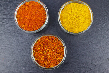 Set of different aromatic spices on black slate. Top view
