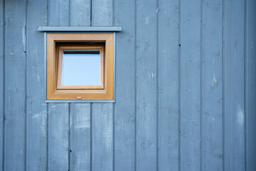 Fototapeta na wymiar Wooden grey blue texture of wooden house wall and little window
