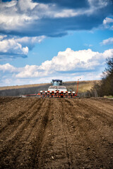 sowing work in the field. Tractor with seeder