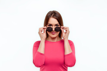 Beautiful young girl in glasses and a pink dress on a white background. Happiness, spring, holiday.