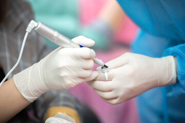 The tattoo artist is mixing the colors with the eyebrow tattoo needles. While wearing a hand grip for safety