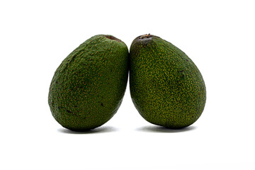 two fruits of green ripe avocado on a white background close-up