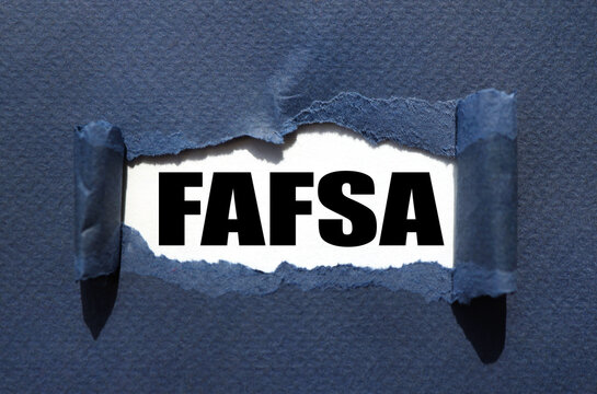 Free Application for Federal Student Aid (FAFSA). text on white paper over torn paper background.