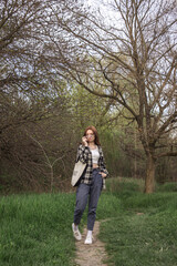 The girl walks along the path in nature. Spring walk through the woods. Girl teenager on the background of nature