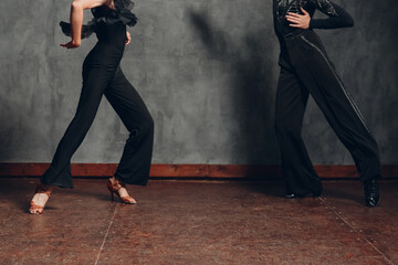 Young couple in black dress dancing in ballroom dance cha-cha-cha