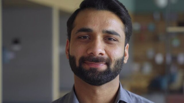 Portrait of young confident indian business man executive looking at camera. Eastern male professional teacher, smiling ethnic bearded entrepreneur or manager in office, close up face headshot.