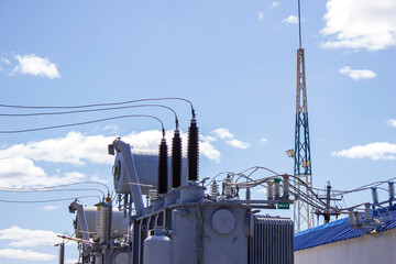 High-voltage current transformer on a blue sky background. Electric current redistribution...