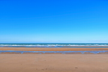 Fototapeta na wymiar La plage de sable de Omaha beach en France, en Normandie, dans le Calvados, au bord de la Manche.