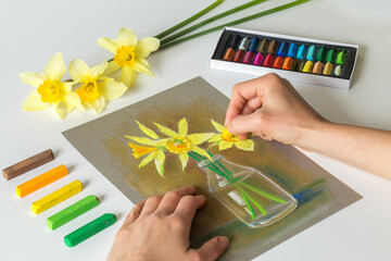 Pastel painting of flowers with artist's hands. Painting at home. 