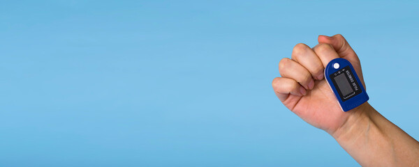 Fototapeta premium A pulse oximeter is on the woman's hand. A pulse oximeter used to measure heart rate and oxygen levels.. Covid-19.Banner