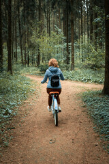 Blond woman with bike in the woods.