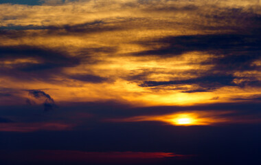 Obraz premium beautiful sunset sky, bright sun and dark silhouette of clouds as a background