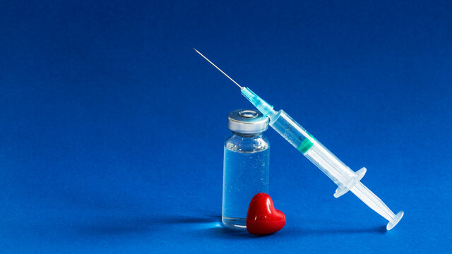 The vaccination fluid bottle with a syringe and a little red heart