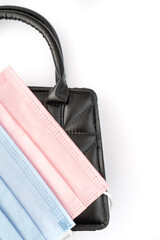  pink and blue protective masks in a black elegant handbag