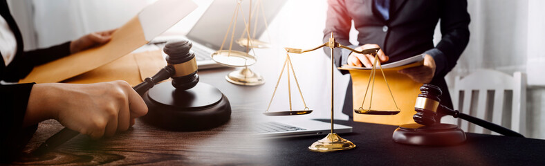 Justice and law concept.Male judge in a courtroom with the gavel, working with, computer and...