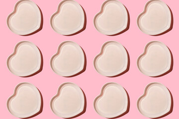 Heart shaped plate. Ceramic tableware. On a pink background. With a hard shadow. Pattern.