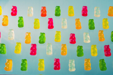 multicolored chewing candy in a row on gray background
