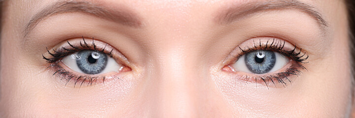 Pair of beautiful deep blue female eyes looking in camera