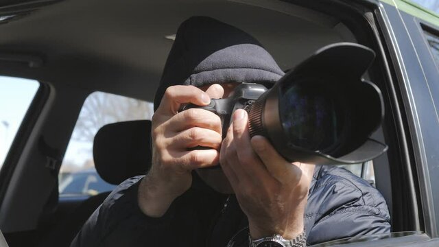 Surveillance and operational photography from the car window. A man secretly takes photos hiding in the car.