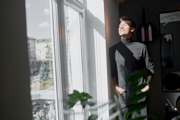 Male happy smiling hairdresser at his modern salon