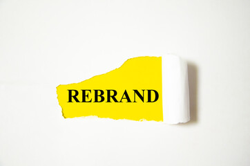 REBRAND the text is written on a white background and a yellow piece of paper
