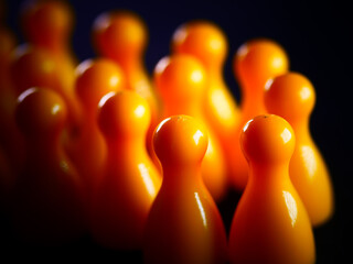 Studio shot of yellow monopoly plastic chips on black background