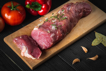 Raw beef meat with vegetables ingredients over cutting board. Preparation before preparing food in restaurant or cafe