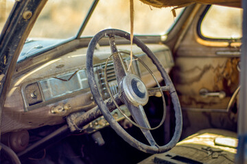 Interior view of the dash board of an old junked retro vehicle in a junkyard.