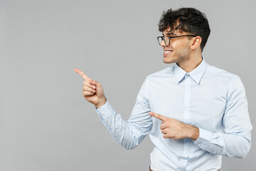 Young employee business latin man corporate lawyer in classic white shirt glasses point index finger aside on copy space area mock up isolated on grey background studio. Career achievement concept.