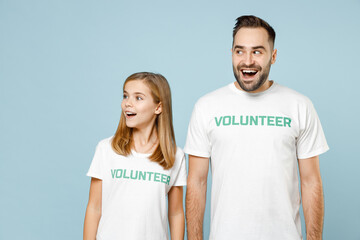 Two young friends couple teen girl man wears white t-shirt green title volunteer looking aside...