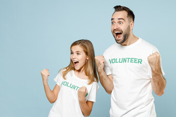 Two fun young friends couple teen girl man wears white t-shirt green title volunteer celebrating isolated on pastel blue color background Voluntary free team work assistance help charity grace concept