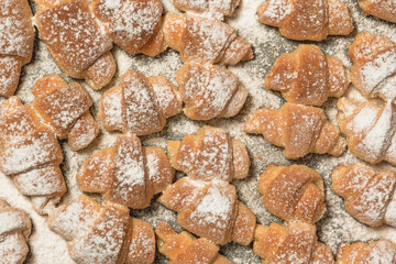 Homemade cakes, on a baking sheet fresh baked in the oven bagels made of cottage cheese dough sprinkled with powdered sugar