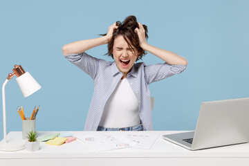 Young troubled stressed employee business woman 20s in casual shirt sit work at white office desk...