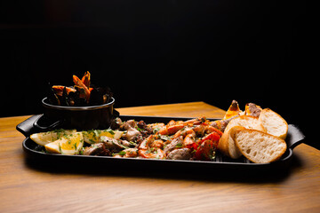 Side view photo of a big plate with sea food.