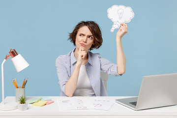 Young pensive employee business woman 20s in shirt sit work at white office desk with pc laptop...