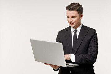 Young employee business corporate lawyer man wearing classic formal black grey suit shirt tie work in office hold laptop pc computer chat online browsing isolated on white background studio portrait