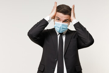 Young trouble employee business corporate lawyer man in classic black suit tie sterile face mask from coronavirus covid-19 pandemic quarantine work in office hold head isolated on white background.