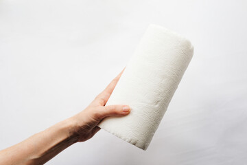 Female hands that hold rolls of paper towels, napkins on a white background. White on white, pulp,...