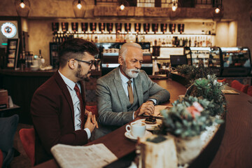  Two businessmen working together in modern cafe.