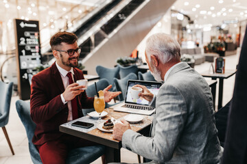  Two businessmen working together in modern cafe.
