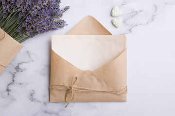Top view of a blank sheet of paper in an envelope, lavender and hearts. Spring or summer concept
