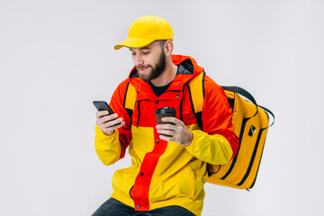 young courier is drinking coffee while waiting for the order, wa