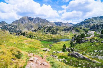 Fototapeta na wymiar Mountainous landscape with beautiful green mountains and a lake on a sunny day. Concept of mountain trip and summer vacations. Circo Saboredo, Aran Valley-Pyrenees, Catalonia, Spain.