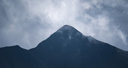 Peak of a high mountain on a cloudy day. Mountain range. Mountaineering and nature concept.